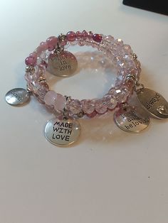 This sparkly pink faceted glass memory wire charm bracelet adorned with sweet messages of love, offers a delightful blend of elegance and affection. Each intricately faceted glass bead radiates a mesmerizing sparkle, adding a touch of enchantment to your wrist. Adorned with delightful love-inspired charms, this bracelet resonates with warmth and affection. The flexible memory wire ensures a comfortable fit for all wrists, allowing you to carry a glistening reminder of love and beauty wherever yo Wire Charm Bracelet, Wire Charm, Crystal Bead Jewelry, 108 Bead, Sweet Messages, Bangle Bracelets With Charms, Memory Wire, Charm Bangle, Strand Bracelet