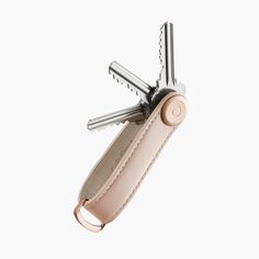 a pink leather case holds two multi - function swiss army knifes, which are open to show the blades