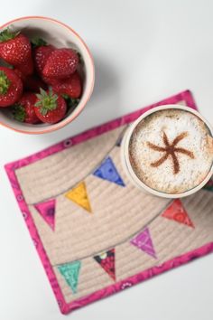 there is a cup of coffee and some strawberries on the table