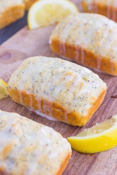 lemon poppy seed muffins with icing on a cutting board next to sliced lemons