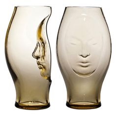 two glass vases that have faces on them