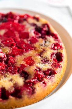 a close up of a cake on a plate with cranberries and other toppings