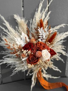 a bridal bouquet with red roses, white and orange flowers