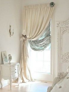 a bedroom with white furniture and curtains