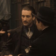 two men in top hats talking to each other