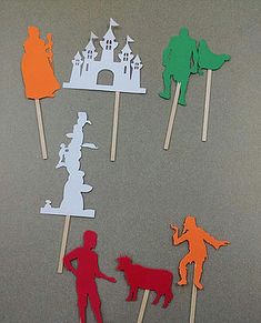 some paper cut out of people and animals on sticks