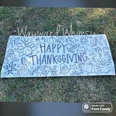 a sign that says happy thanksgiving on the grass