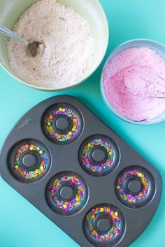 doughnut holes with sprinkles and powdered sugar in bowls on a blue background