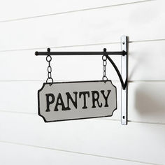 a sign hanging from the side of a white building that says pantry on it's chain