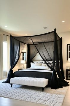 a black canopy bed in a bedroom with white rugs and pillows on the floor