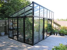 a glass house sitting on top of a wooden deck