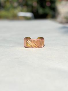 This vintage 70's mixed metal modern cuff bracelet features a striking combination of copper and gold tones. Adorned with abstract decorations, it embodies a boho style that adds a touch of eclectic elegance to any outfit. Its unique design and retro charm make it a perfect statement piece for those who appreciate distinctive, timeless accessories. inner size: 2-1/4 x 2 inches; opening 1-1/4 inches; 1-3/8 inches tall; good condition with some minor fine scratches and stains.  ---------Shipments Artistic Gold Copper Bracelets, Artsy Adjustable Gold Bracelets, Artsy Adjustable Gold Bracelet, Adjustable Artsy Gold Bracelet, Artisan Gold Cuff Bracelet In Copper, Gold Copper Cuff Bracelet, Bohemian Gold Cuff Bracelet In Copper, Bohemian Gold Copper Cuff Bracelet, Unique Gold Copper Cuff Bracelet