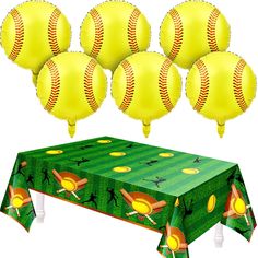 a table topped with lots of yellow baseball balloons