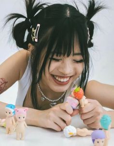 a young woman is playing with small toys