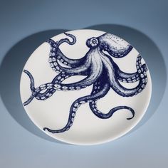 a blue and white plate with an octopus design on the front, against a gray background