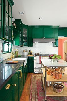 a kitchen with green cabinets and white counter tops