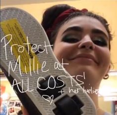 a woman holding up a skateboard with the words protect millie at all cost