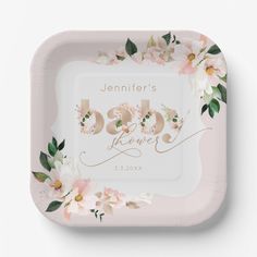 a pink and white baby shower plate with flowers on the front, in gold foil lettering