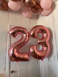 the number twenty two balloons are hanging from the ceiling with pink and gold streamers