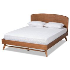 a bed with white pillows and wooden headboard