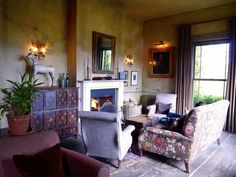 a living room filled with furniture and a fire place in the middle of it's walls