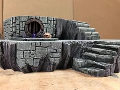 there is a miniature castle made out of rocks and stone blocks with a hole in the middle