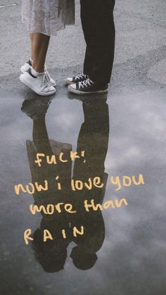 two people standing next to each other in front of a puddle with words written on it