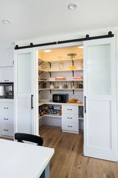 an open kitchen with white cabinets and sliding doors