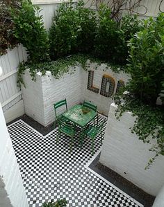 an image of a small courtyard with white walls and black and white tiles