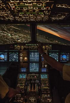 two pilots in the cockpit of an airplane at night