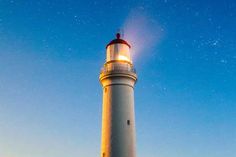 a white and red light house with stars in the sky