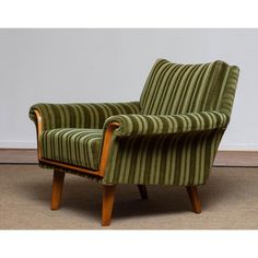 a green striped chair sitting on top of a carpeted floor next to a white wall