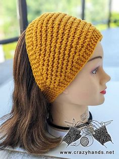 a mannequin head wearing a yellow knitted hat on top of a white table