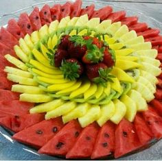 a platter with watermelon, bananas and strawberries arranged in the shape of a flower