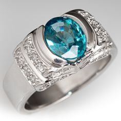 a ring with blue topaz and diamonds on the sides, set in 18k white gold