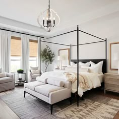 a bedroom with a four poster bed and white furniture