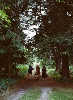 three people walking down a dirt road with trees in the background and a quote written on it