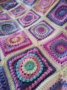 a crocheted blanket with squares and circles on it