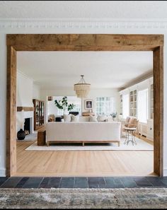 an open living room with white furniture and wood accents