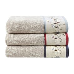 three towels stacked on top of each other in front of a white background with floral designs