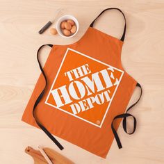 an orange apron with the words the home depot on it next to utensils