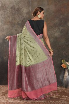 Be vision of elegance on special occasions in this pastel green georgette sari. The saree is enhanced with antique zari buta and antique zari pink border. It comes with a matching blouse piece. Disclaimer: The shown stitched blouse on the model is for display purpose only. The saree comes with a matching blouse piece and finished with fall and piko.