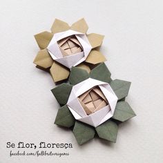 three origami flowers on top of each other with one folded in the middle