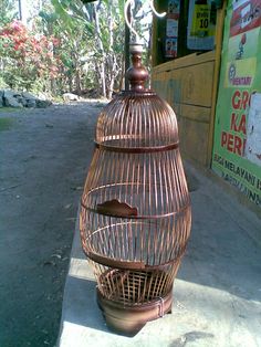 a bird cage sitting on top of a sidewalk