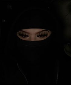 a woman wearing a black hoodie and looking at the camera with her eyes closed