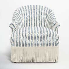 a blue and white chair with fringes on the back, in front of a white background