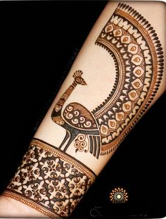 a henna tattoo design on someone's arm with an intricate pattern and bird