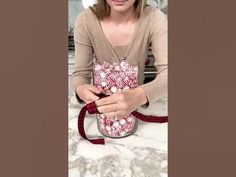 a woman sitting on the floor holding a red and white bag with candy in it