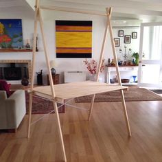 a living room filled with furniture and a wooden table on top of a hard wood floor