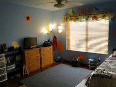 a child's bedroom with blue walls and yellow curtains